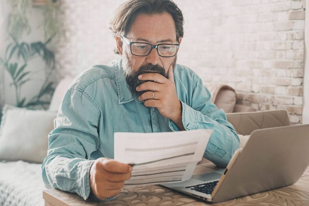 a concerned man reading his water bill because there was a small leak somewhere